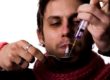 Young addict with heroin syringe injection and spoon