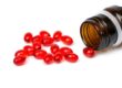 Red capsules spilling from a prescription medicine bottle