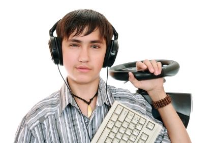 A boy with headphones on holding keyboard and joy stick