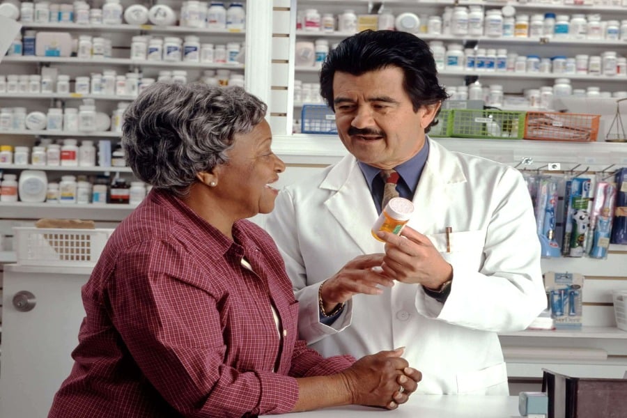 Senior woman discusses medicare part d with pharmacist