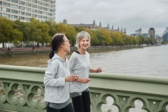 An image of two senior women talking while jogging, emphasizing the advantages of obtaining prescription drugs from Canada
