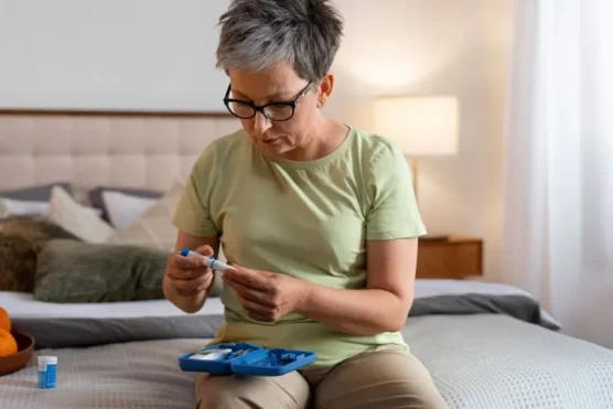 An image of a senior woman examining an EpiPen injector and reading the instructions, highlighting the benefits of buying medication from Canada