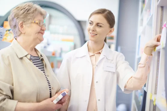 Female pharmacist assisting senior woman