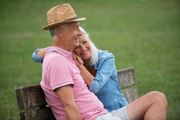 senior couple sitting on a bench in the park