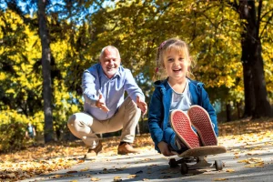 Elderly man joyfully playing with granddaughter outdoors, symbolizing active lifestyle and stroke prevention illustrating what Eliquis is used for