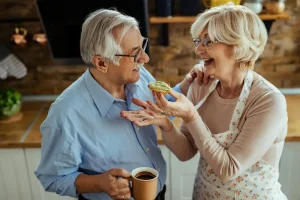 Happy senior couple enjoying breakfast together at home, symbolizing improved quality of life through managing Dexilant cost effectively.