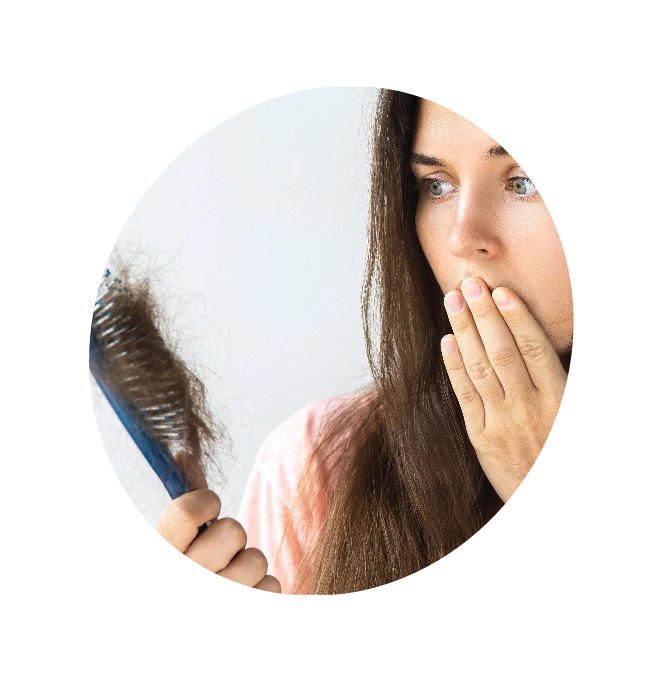 A disbelieved woman staring at a comb in need of hair loss medications
         