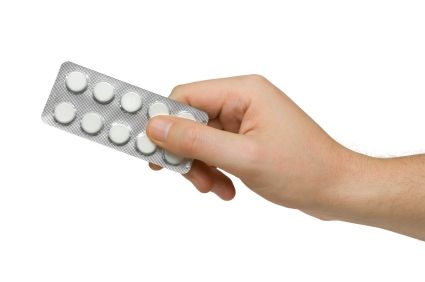Hand giving pills isolated on white background